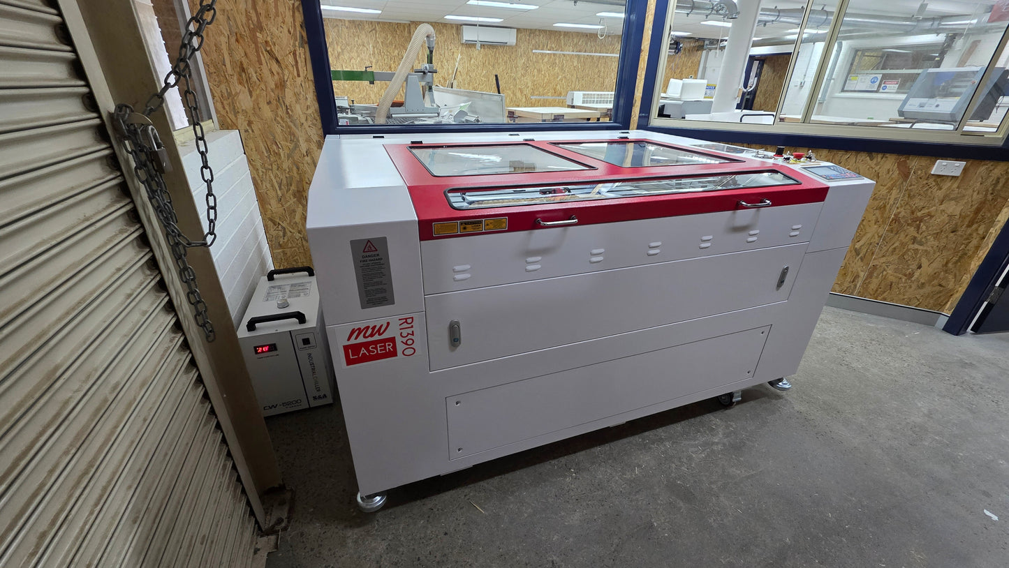 R1390 Laser Machine RECI W4 in a workshop setting, showcasing its robust design and laser cutting features.