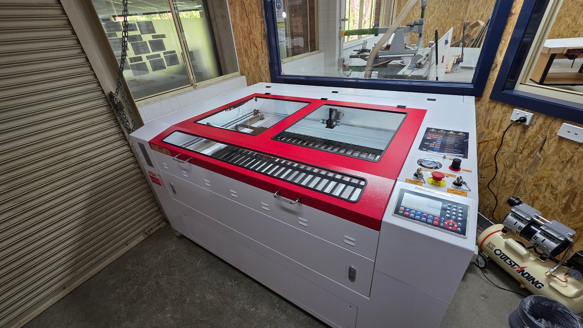 R1390 Laser Machine RECI W4 in a workshop setting, showcasing its controls and enclosed design.