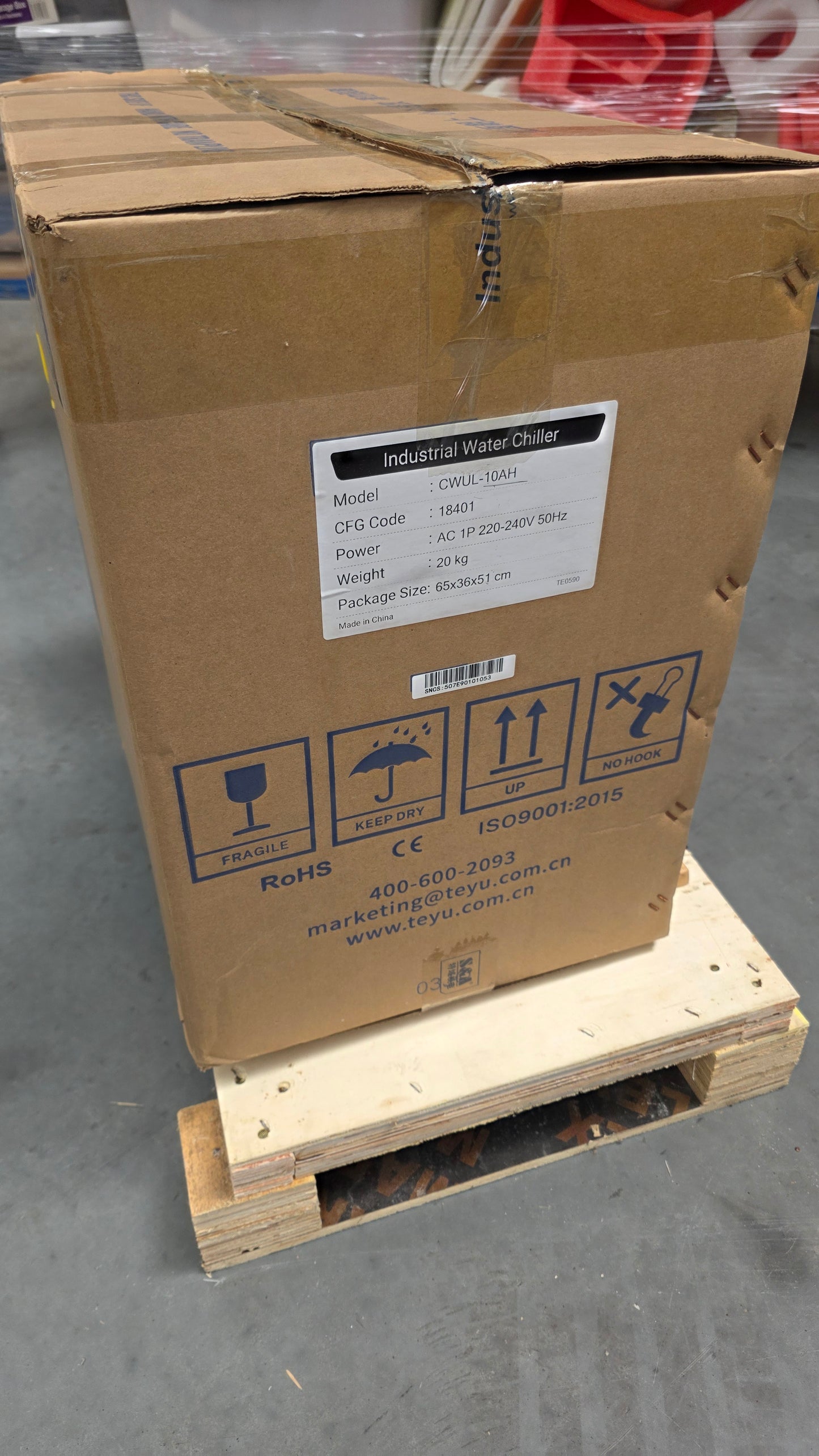 UV Laser Marking Machine - Industrial Water Chiller box with model details and shipping symbols, packaged on a wooden pallet.